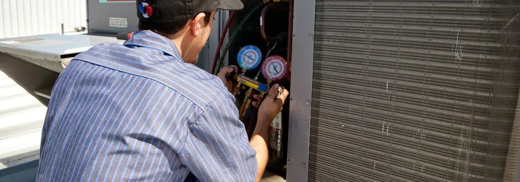 HVAC technician servicing a condenser unit in Coto de Caza